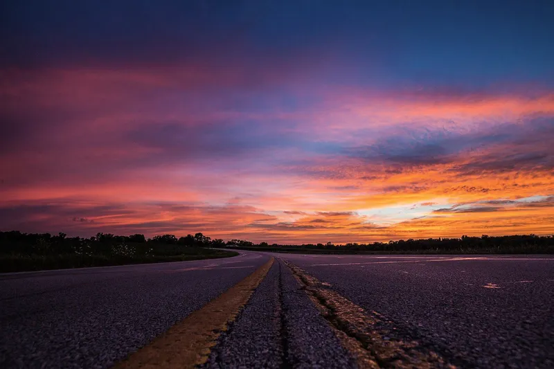 Empty highway under a vivid sunset sky