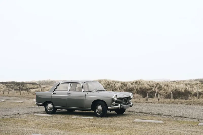 Vintage gray sedan parked near coastal dunes