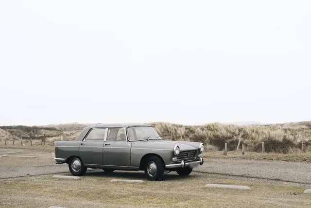 Vintage gray sedan parked near coastal dunes
