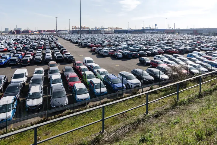 Rows of new cars parked on a large vehicle lot