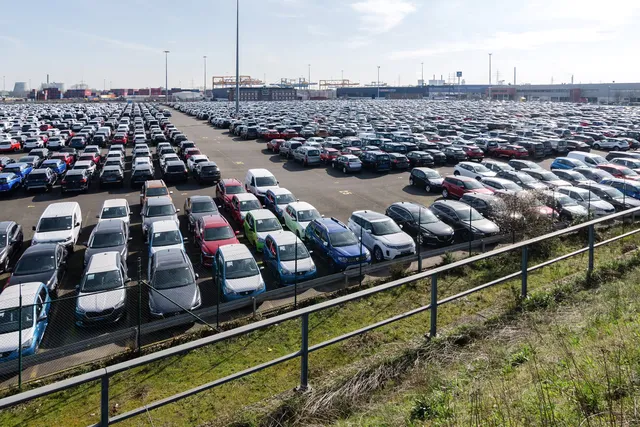 Rows of new cars parked on a large vehicle lot