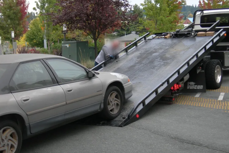 Car being winched onto a flatbed tow truck