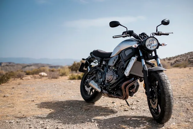 Motorcycle parked on dry ground in a sunny desert landscape