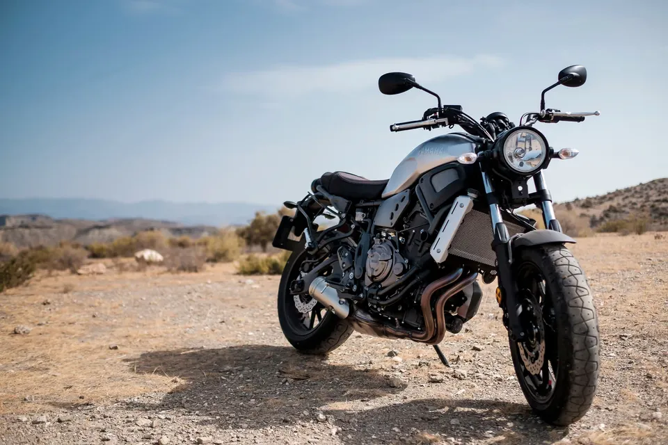 Motorcycle parked on dry ground in a sunny desert landscape