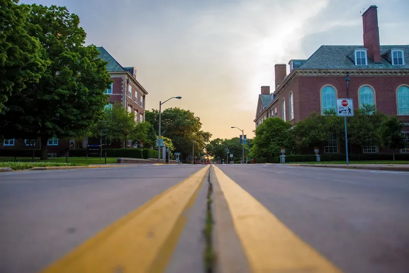 Road running between brick buildings on a university campus