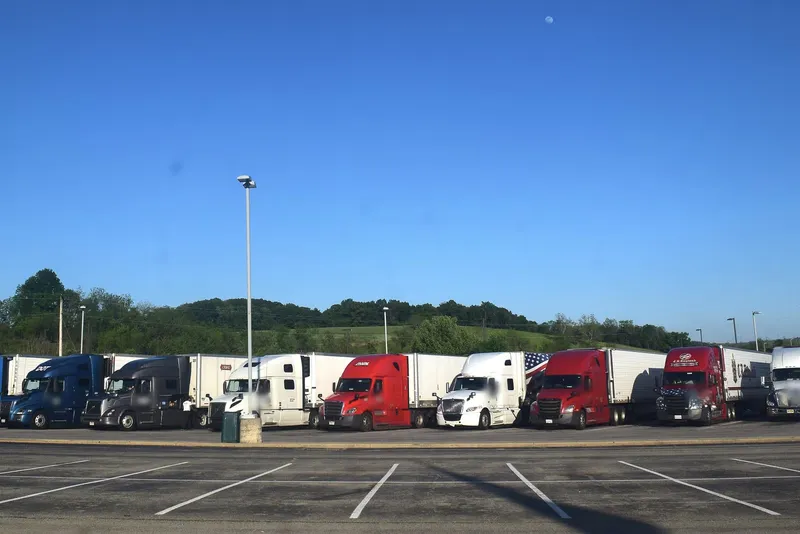 Row of semi trucks parked at a highway truck stop