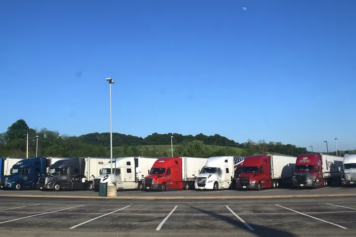 Row of semi trucks parked at a highway truck stop