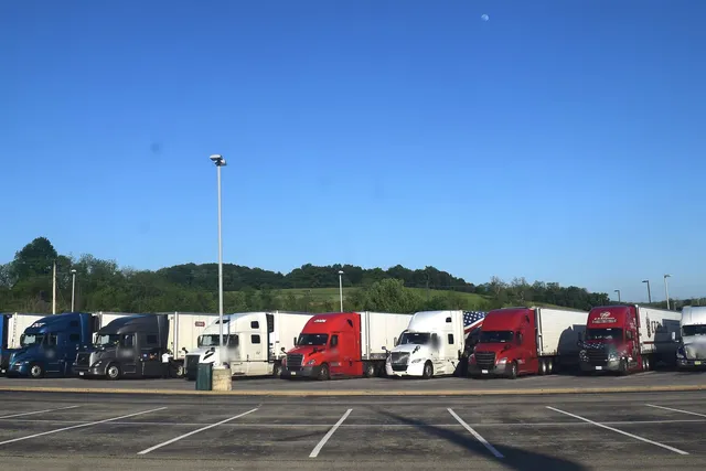 Row of semi trucks parked at a highway truck stop
