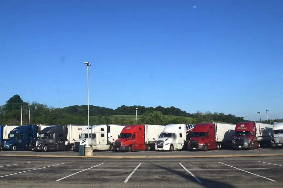 Row of semi trucks parked at a highway truck stop